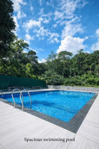 a swimming pool in a yard with a blue sky at Rivera Holidays in Vythiri
