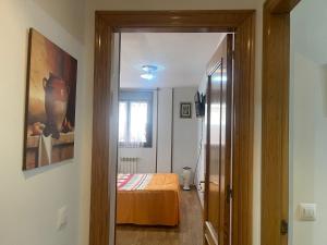a hallway leading to a bedroom with a bed at Amplio Loft con plaza de garaje in Cangas de Onís