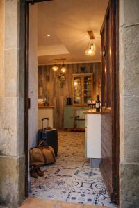 a room with a hallway with a suitcase and a kitchen at Domaine du Prieuré avec Piscine Ancien Couvent & Presbytère in Carcassonne