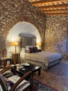 a bedroom with a bed and a stone wall at Can Carbó de Peralada in Peralada