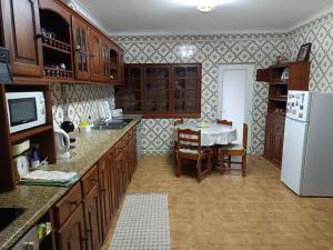 a kitchen with a table and a white refrigerator at Casa da Piedade, Vouzela in Vouzela