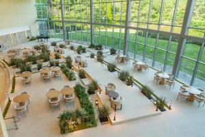 eine Draufsicht auf eine Cafeteria mit Tischen und Stühlen in der Unterkunft WE Hotel Jeju in Seogwipo