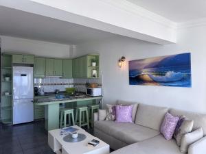 a living room with a couch and a kitchen at Bungalow Atlantic View in Maspalomas