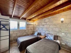 two beds in a room with a stone wall at Bungalow Atlantic View in Maspalomas +55 photos