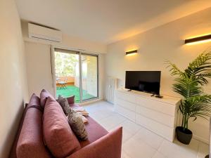 a living room with a couch and a flat screen tv at Cocoon Studio Ciel de Fabron in Nice