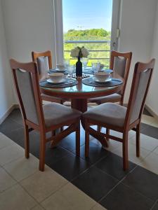 a wooden table with four chairs and a table and a window at Lavanda Samarin in Zambratija