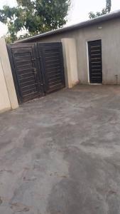 a garage with two doors on the side of a house at Jajoux Homes in Azohoué-Hiho