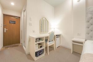 une chambre avec un bureau, un miroir et un lit dans l'établissement Hotel Reference Tenjin III, à Fukuoka