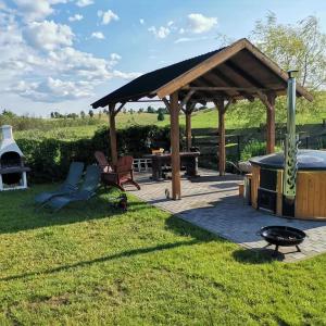a wooden gazebo with a grill and a barbecue at Domek u Patryka in Mrągowo