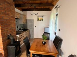 a kitchen with a wooden table and black chairs at Domek u Patryka in Mrągowo