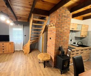 a kitchen with a brick wall and a spiral staircase at Domek u Patryka in Mrągowo