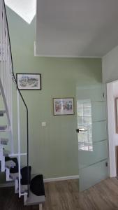 a room with a staircase and a green wall at Schwedenhaus, Am Achterwasser, Urlaub mit Hund in Lütow