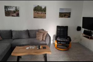 a living room with a couch and a chair at NEU! Ferienwohnung am Ahlberg in Toppenstedt