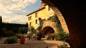 a stone building with an archway in front of it at Can Carbó de Peralada in Peralada