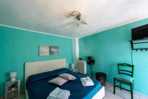 a blue bedroom with a bed and a chair at Àa da Pinèla-Biassa-Cinque Terre in Biassa