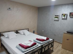 a bedroom with a large white bed with red pillows at Stefi in Bečej