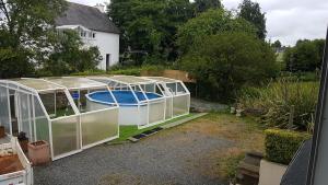 a greenhouse with a pool in it in a yard at Maison familiale Villa Eolie, 10mn de la mer en voiture in Tregueux