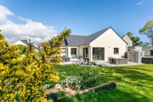 a white house with a yard with yellow flowers at Chambre d'hôtes Marine in Binic