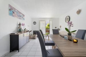 a kitchen and dining room with a table and chairs at Le Cocon De Laurence in Pleurtuit +19 photos