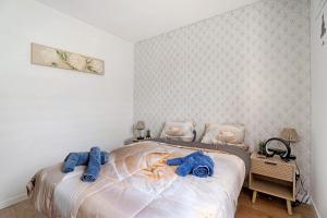 a bedroom with a bed with blue towels on it at Le Cocon De Laurence in Pleurtuit
