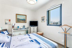 a bedroom with a bed and a tv and a window at Chambre d'hôtes Marine in Binic