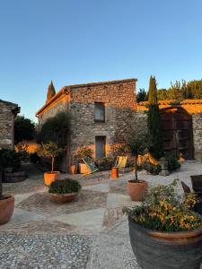 a stone house with a courtyard with potted plants at Can Carbó de Peralada in Peralada +15 photos