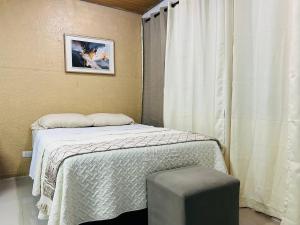 a small bedroom with a bed and a window at Suite Antiguo in Antiguo Cuscatlán