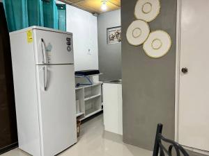 a kitchen with a refrigerator and straw hats on the wall at Suite Antiguo in Antiguo Cuscatlán