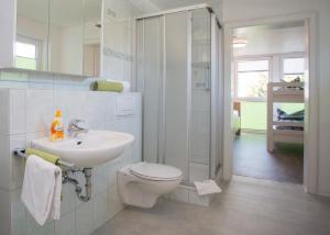 a white bathroom with a toilet and a sink at Haus Jungmann in Hallenberg +18 photos