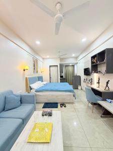 a bedroom with a bed and a blue couch at The Sakshi suite - Luxury Saty with Premium Comfort in Jaipur