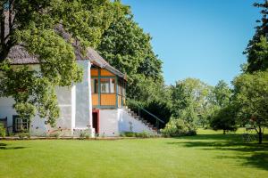 a house with a thatched roof and a yard at Tôlluste Villa in Tõlluste