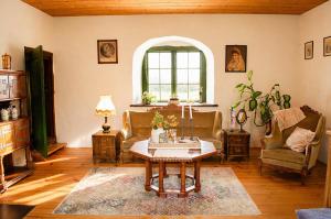 a living room with a table and chairs and a window at Tôlluste Villa in Tõlluste