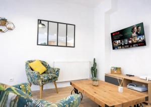 a living room with a table and a chair at Le Repaire des 12- Hypercentre, jardin, idéal groupe, 5 chambres 5 salles de bain in Saint-Omer