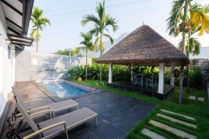 a gazebo with chairs and a table and a pool at DARZA LUXURY RESORTs in Coimbatore