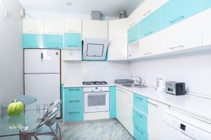 a kitchen with blue cabinets and white appliances at City View 2BR With Balcony, Steps To Cascade And North Avenue l New Building in Yerevan