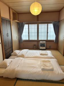 a bedroom with three beds and a television in it at AOMORI LOVERS Minatomachi Base in Aomori