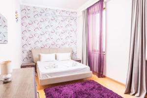 a bedroom with a white bed with a purple rug at City View 2BR With Balcony, Steps To Cascade And North Avenue l New Building in Yerevan