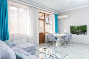 a living room with a white couch and a table at City View 2BR With Balcony, Steps To Cascade And North Avenue l New Building in Yerevan