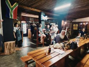a group of people sitting at a table in a bar at Hazyview Adventure Backpackers in Hazyview +46 photos