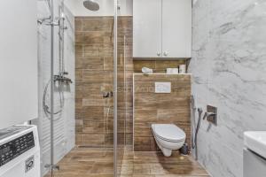 a bathroom with a toilet and a glass shower at Walter&Sons Apartment Centro in Poděbrady +12 photos