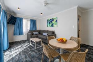 a living room with a couch and a table and chairs at Cairns Southgate Hotel in Cairns