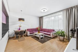 a living room with a purple couch and a table at Walter&Sons Apartment Centro in Poděbrady