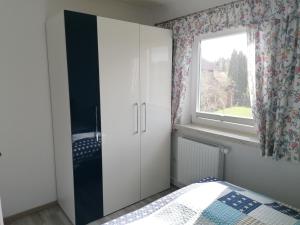 a bedroom with a white cabinet and a window at Haus Bischoff 1 in Halblech +10 photos