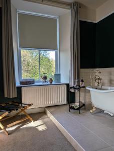 a bathroom with a tub and a large window at The King's Head, Lanchester in Durham