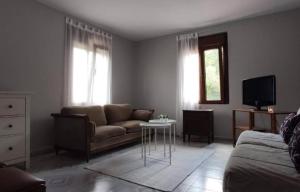 a living room with a couch and a tv at Estación celorio in Celorio