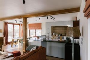 a kitchen and living room with a couch and a table at La Maison des Champs in Ciney