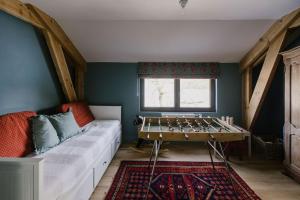 a room with a couch and a pool table at La Maison des Champs in Ciney