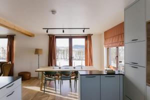 a kitchen with a table and chairs in a room at La Maison des Champs in Ciney +36 photos