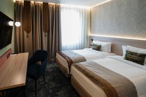 a hotel room with two beds and a desk at Yourta in Oral