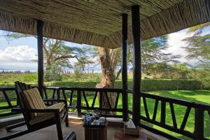a porch with two chairs and a tree at Sawela Lodges in Naivasha